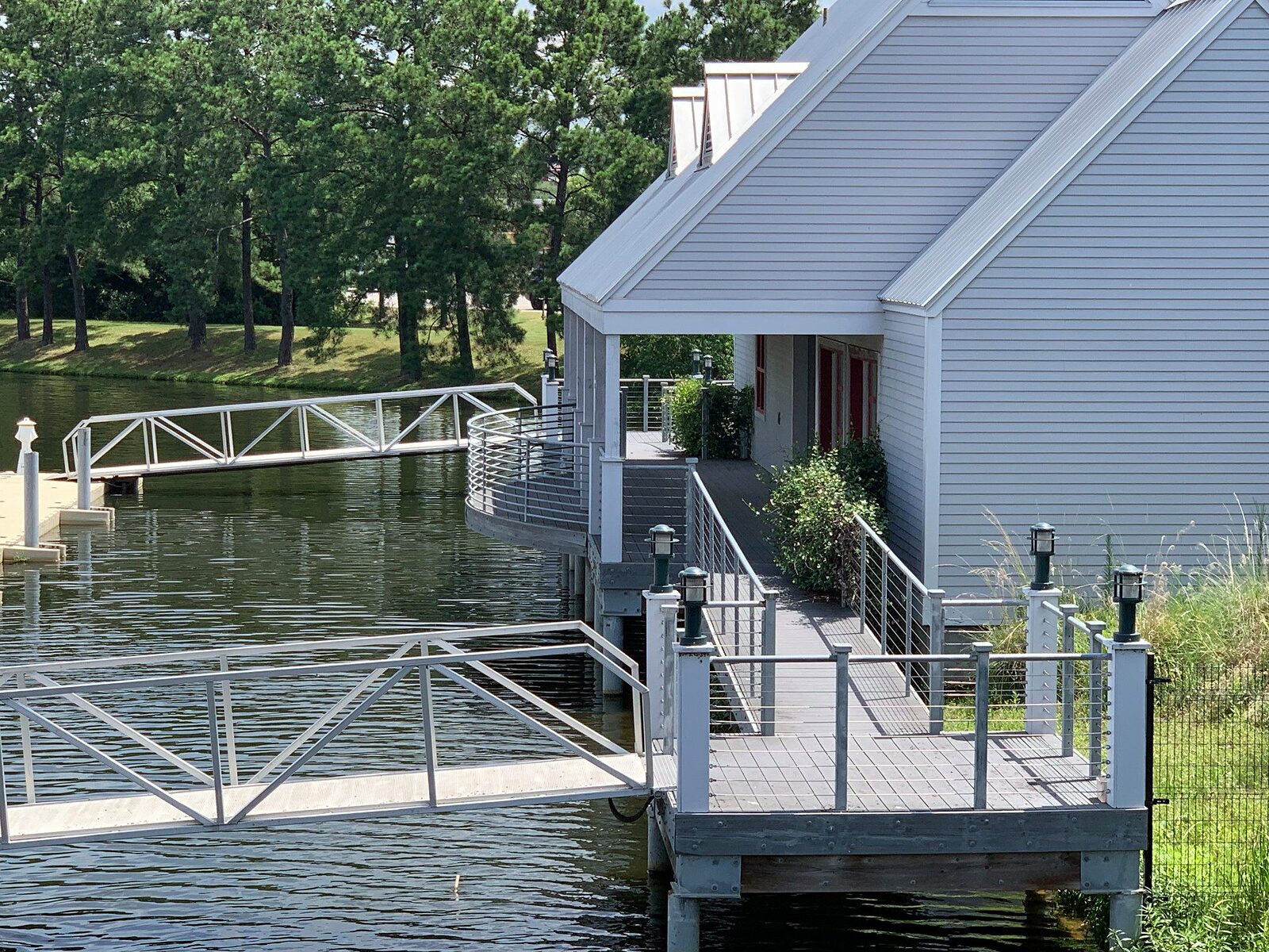 Aluminum gangways running down to railed floating docks alongside a waterfront building