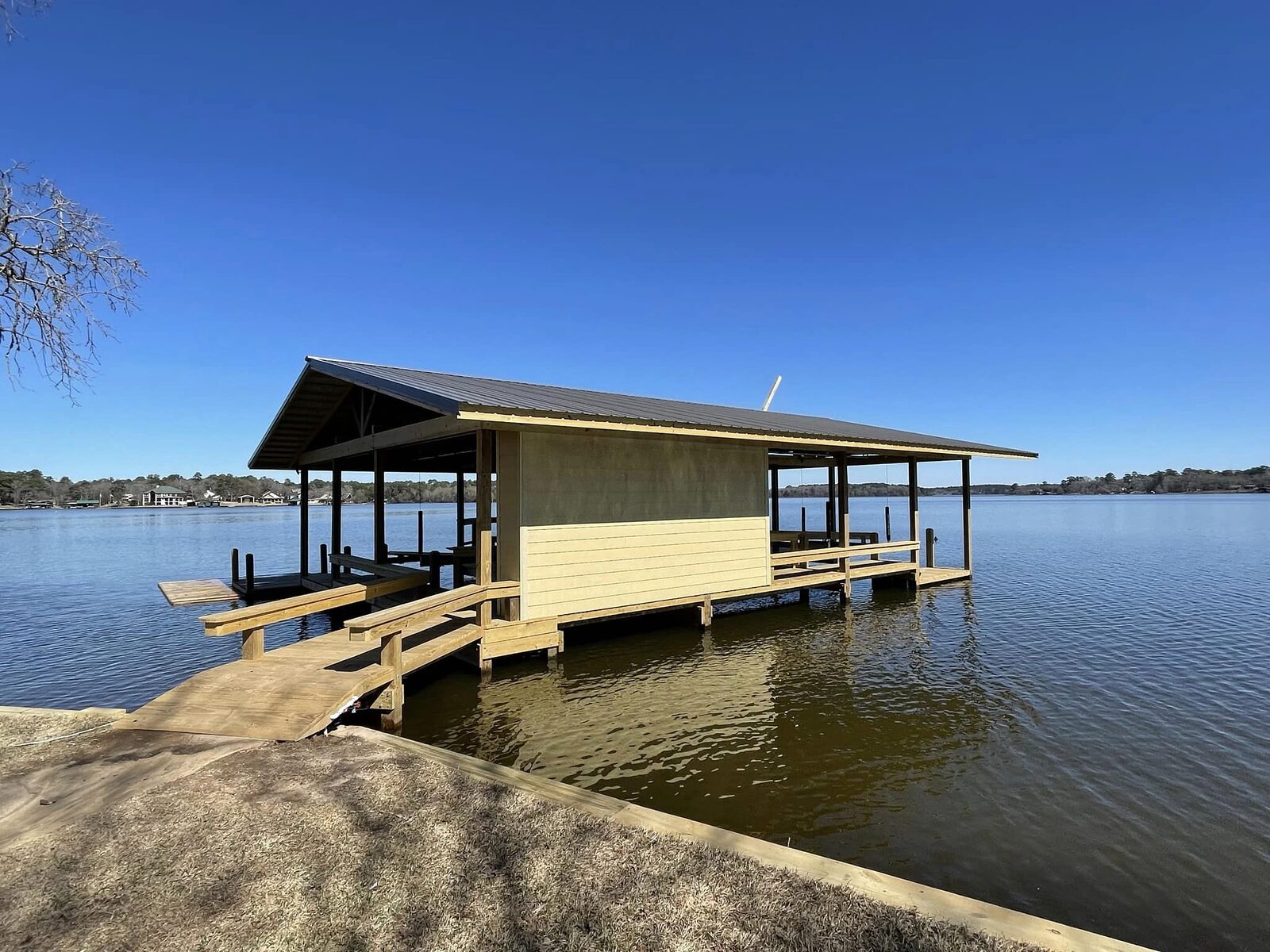 Boathouse with metal roof, enclosed storage room and side walkway built over Houston County Lake