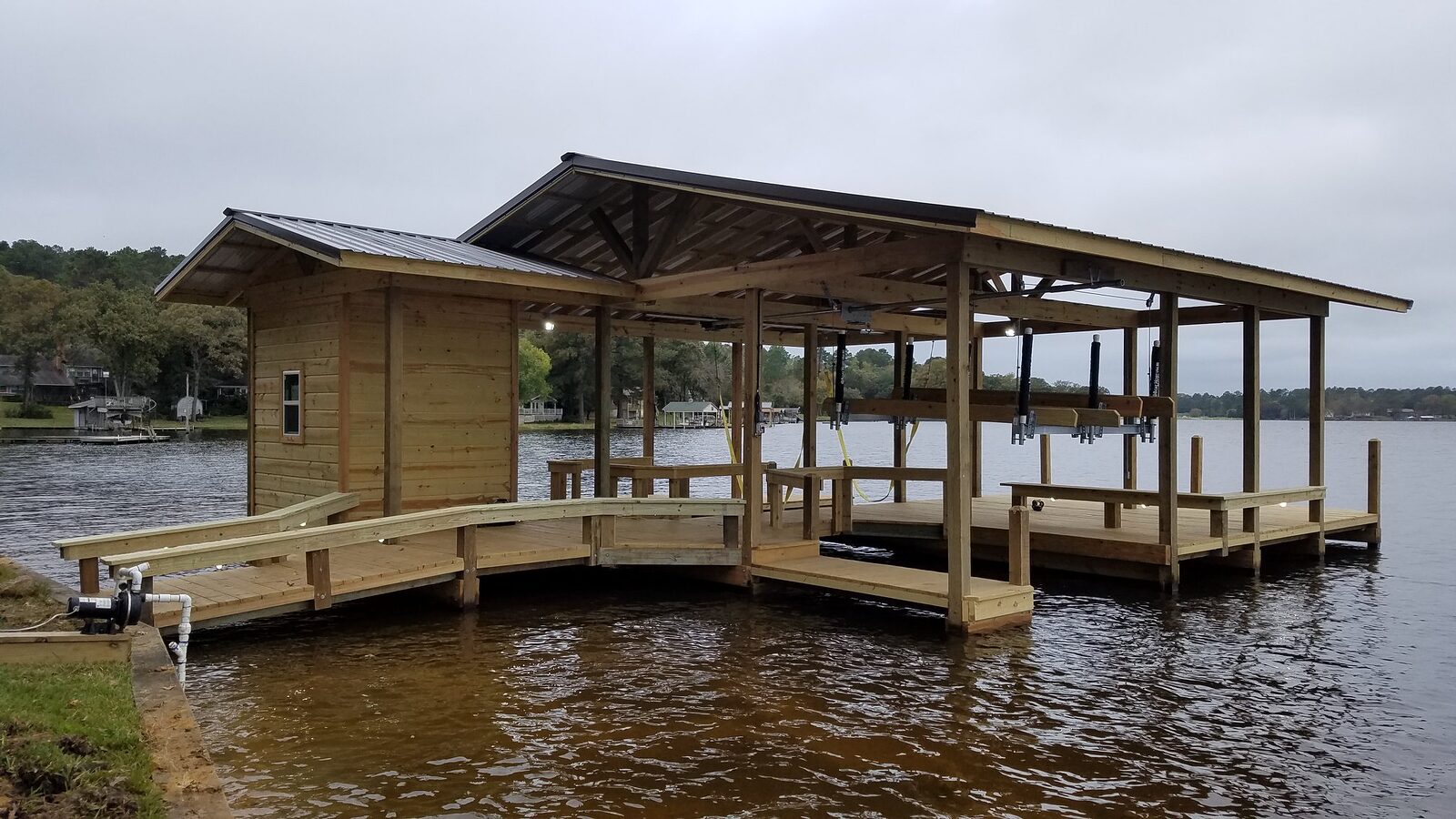 Completed covered boathouse with boat lifts, storage room and curved walkway on Lake Livingston