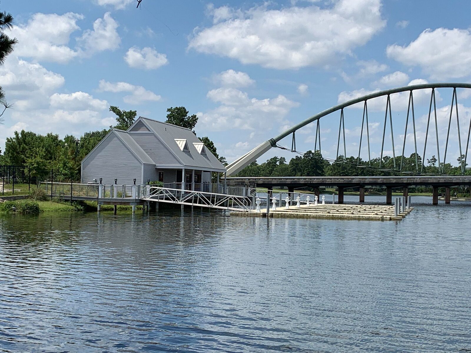 Pile-supported marina terminal building with an aluminium gangway running down to floating finger docks