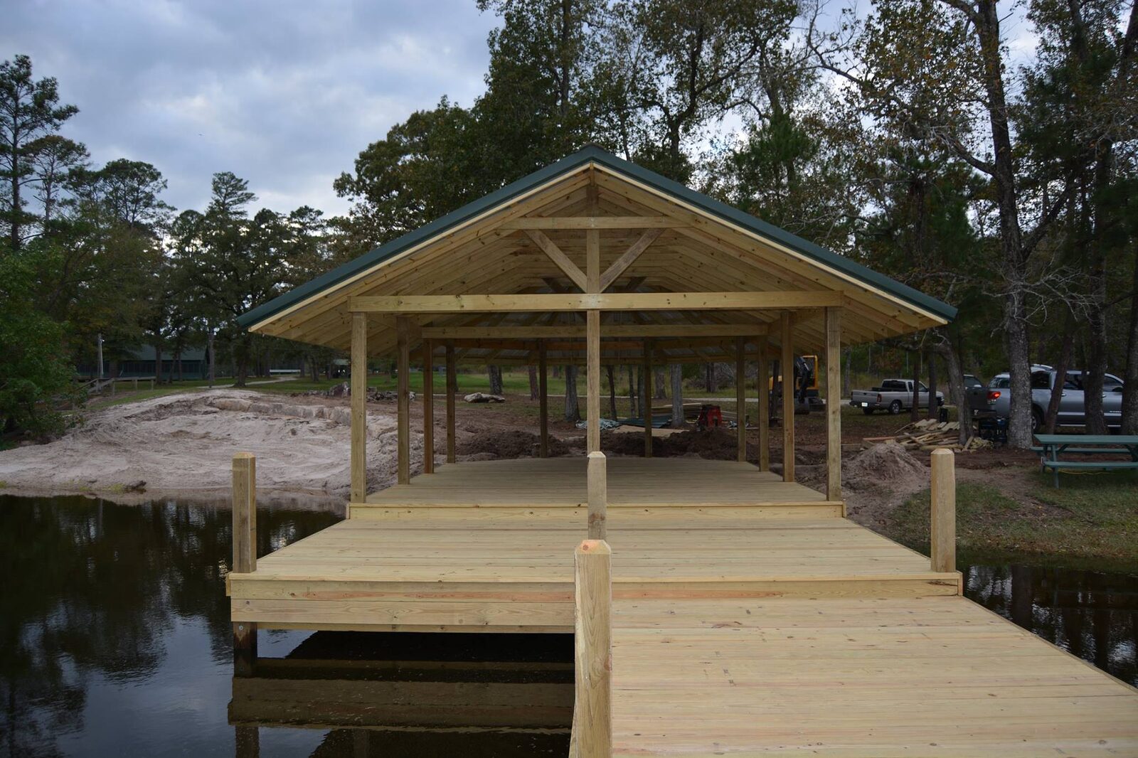 New wooden dock decking leading straight into a covered shelter with a gabled metal roof