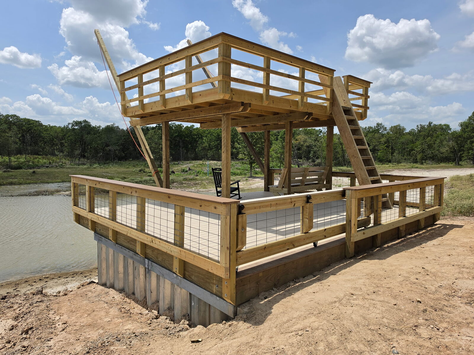 Upper observation level of the private pond swim deck, railed and carried on braced timber posts above the main deck