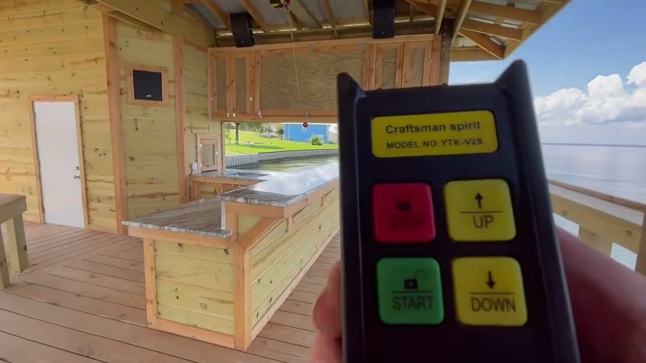 Inside a finished Shoretech boathouse on Lake Livingston, timber walls and a stone-topped counter, with the open lake beyond the slip